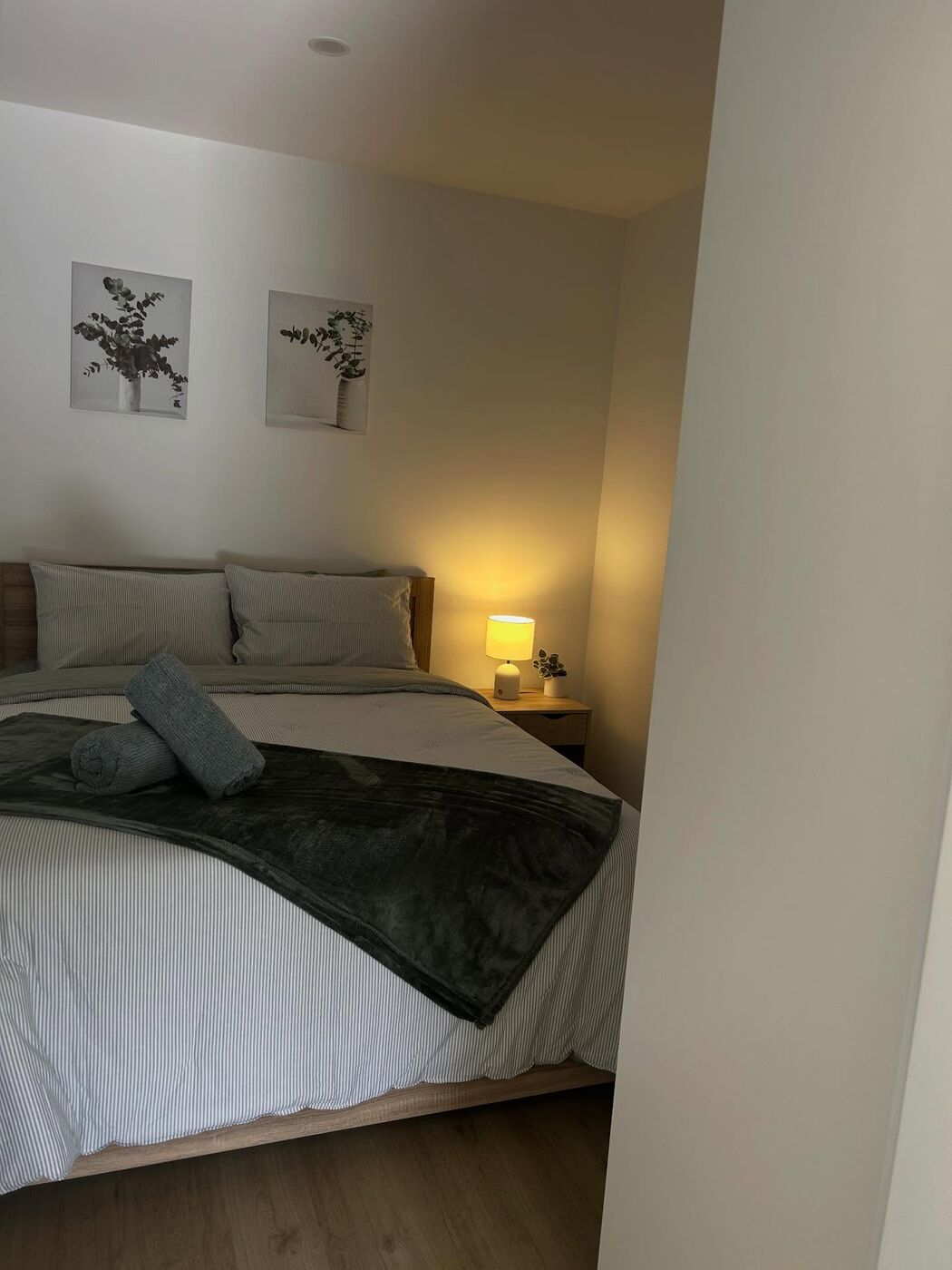 Cabin bedroom with striped linen and a warm bedside lamp